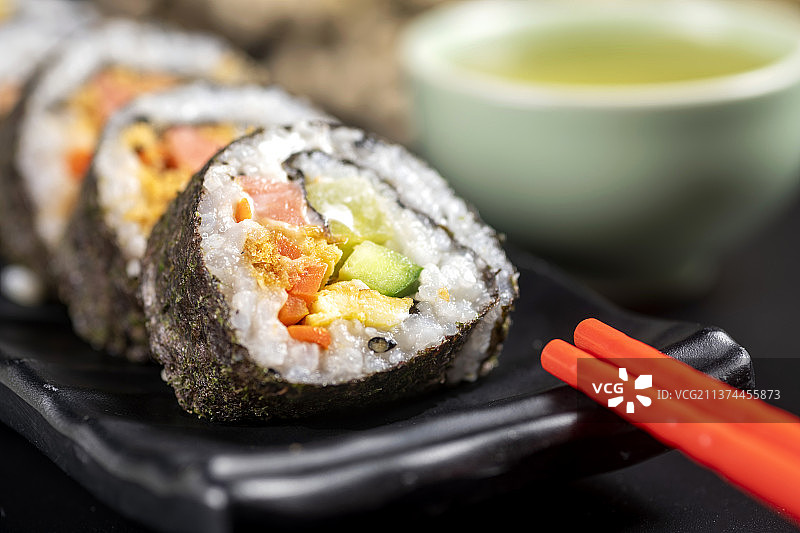 一盘紫菜包饭特写黑色背景图片素材