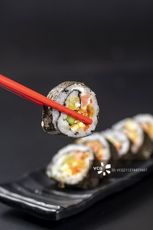 一盘紫菜包饭特写黑色背景图片素材