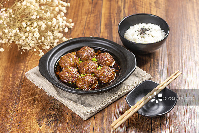 一盘红烧丸子与米饭放在木桌面上特写图片素材