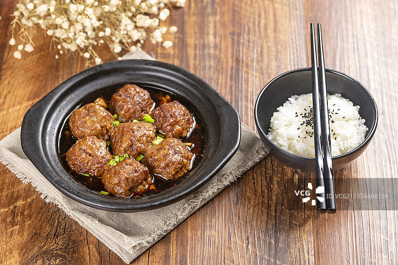 一盘红烧丸子与米饭放在木桌面上特写图片素材
