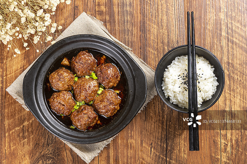 一盘红烧丸子与米饭放在木桌面上特写图片素材