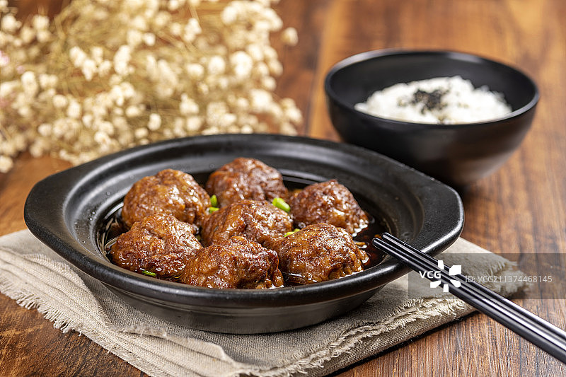 一盘红烧丸子与米饭放在木桌面上特写图片素材