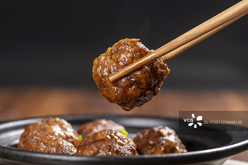 一盘红烧丸子与米饭放在木桌面上特写图片素材