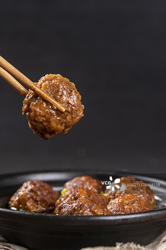 一盘红烧丸子与米饭放在木桌面上特写图片素材