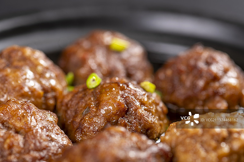 一盘红烧丸子与米饭放在木桌面上特写图片素材