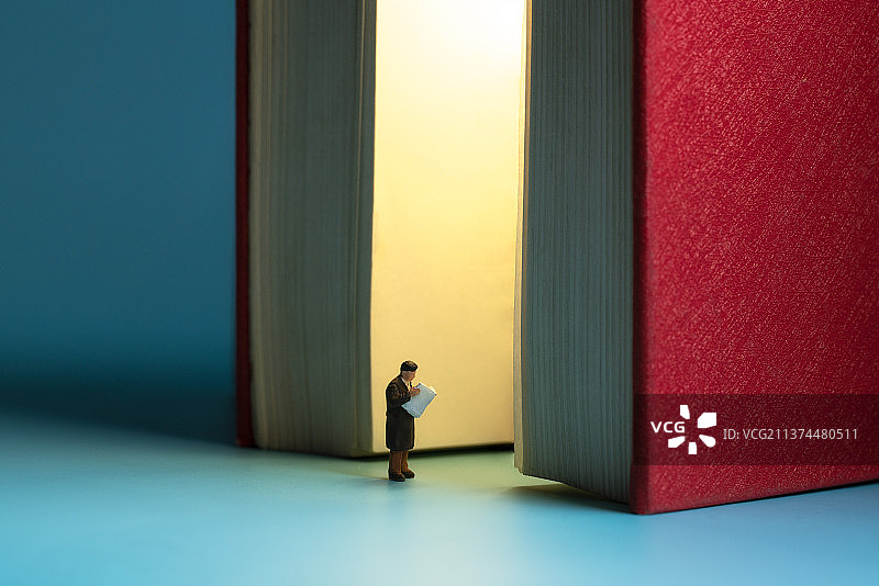 站在透光的书本边阅读的人微缩创意图片素材