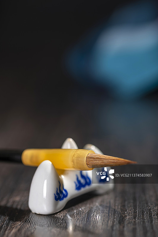 一直毛笔架在笔架上特写木桌面深色调图片素材