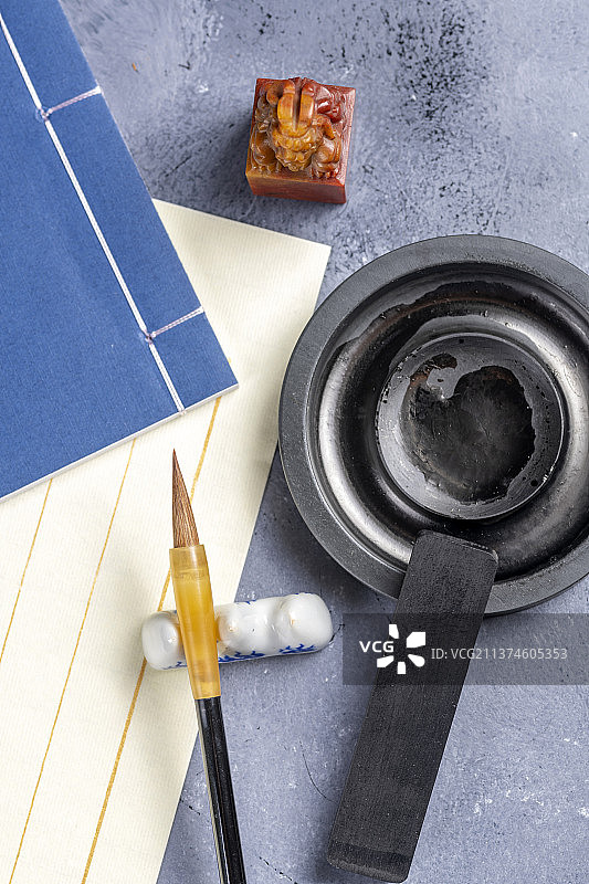 文房四宝毛笔宣纸砚台线装书印章香炉摆放在桌面上图片素材