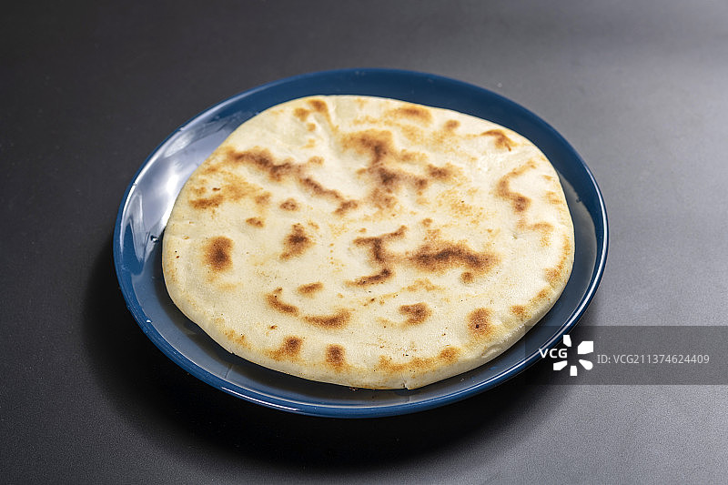 切开的发面饼摆放在木砧板上与整张发面饼特写黑色背景图片素材