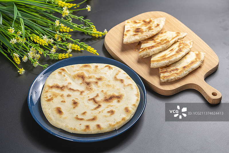 切开的发面饼摆放在木砧板上与整张发面饼特写黑色背景图片素材