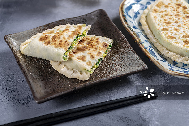 一盘韭菜盒子特写水泥桌面背景图片素材