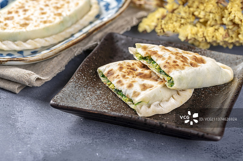 一盘韭菜盒子特写水泥桌面背景图片素材