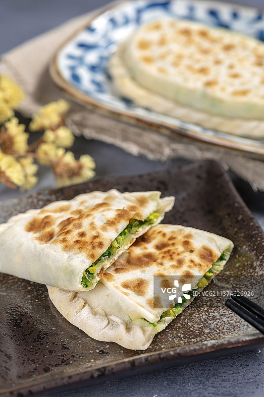 一盘韭菜盒子特写水泥桌面背景图片素材