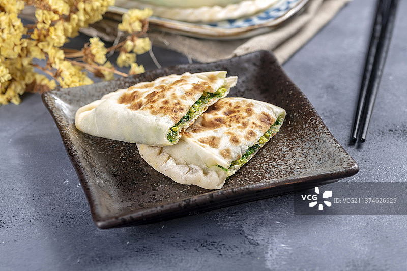 一盘韭菜盒子特写水泥桌面背景图片素材