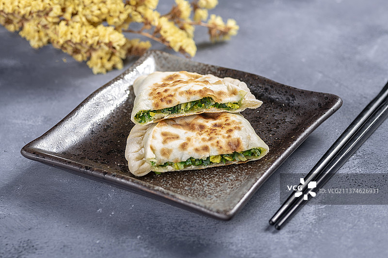 一盘韭菜盒子特写水泥桌面背景图片素材