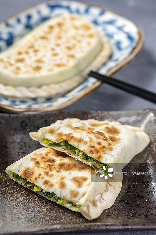 一盘韭菜盒子特写水泥桌面背景图片素材