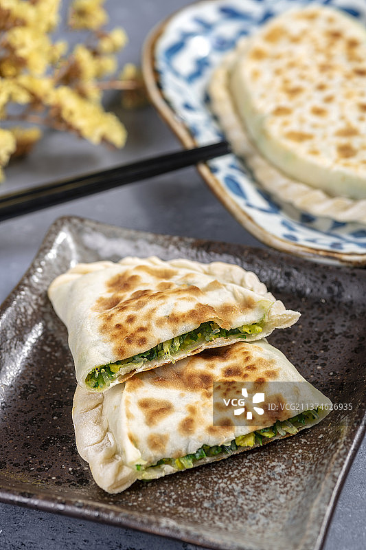 一盘韭菜盒子特写水泥桌面背景图片素材