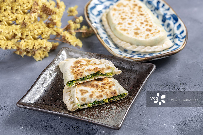 一盘韭菜盒子特写水泥桌面背景图片素材