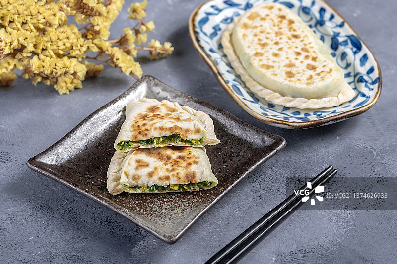 一盘韭菜盒子特写水泥桌面背景图片素材