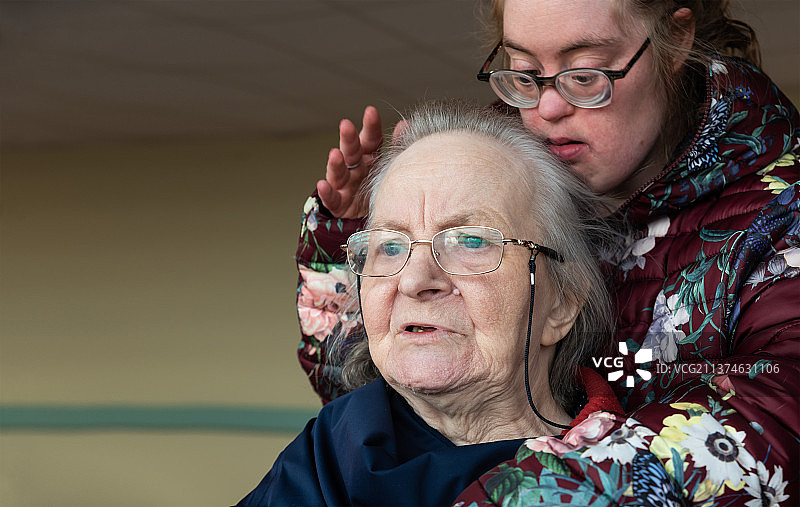 患有唐氏综合征的女儿抱着她的母亲，比利时蒂嫩图片素材