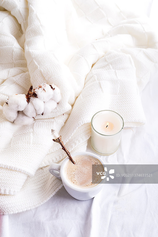 蓬松针织格子和咖啡杯的床上用品，棉花和蜡烛舒适的一天图片素材