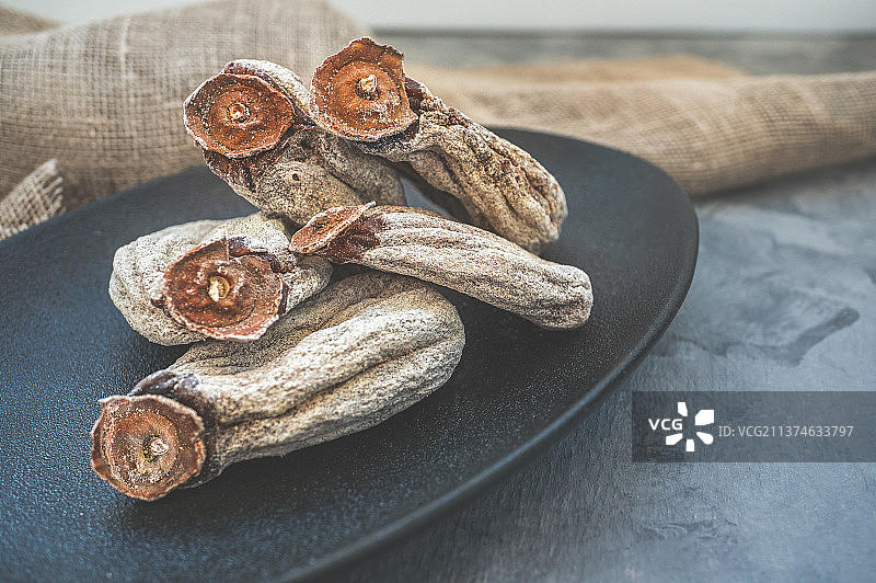 黑色盘子上的柿饼特写，留白图片素材