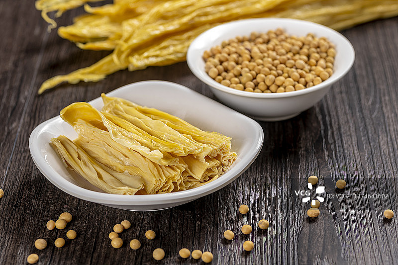 一捆干腐竹与一盘泡发腐竹及黄豆特写图片素材