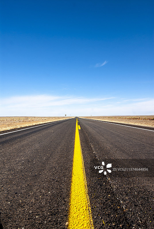 美国加利福尼亚州蓝天下田野间的空旷道路图片素材