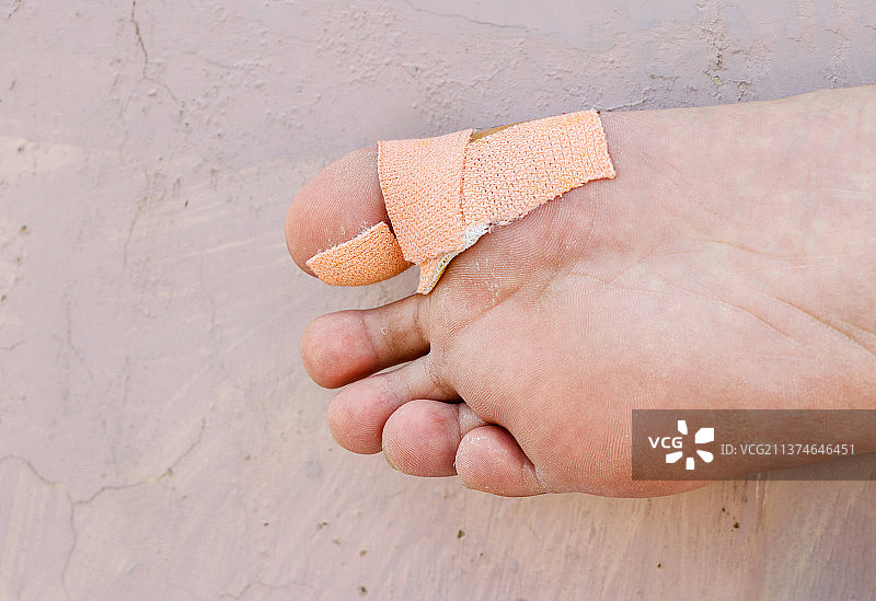 男孩大脚趾上绷带的特写，有选择性聚焦图片素材