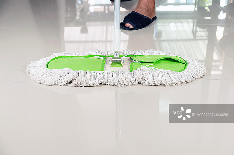 清洁瓷砖地板，男子清洁瓷砖地板的下半部分图片素材