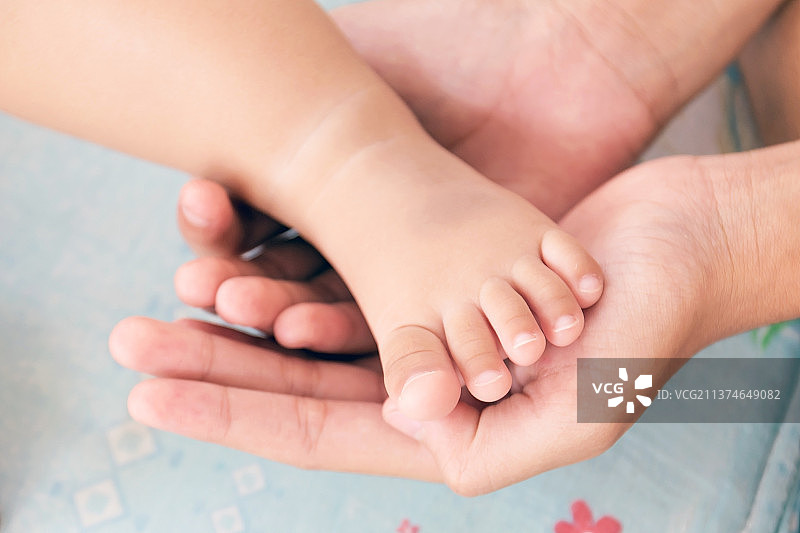 母亲的手呵护着婴儿的脚图片素材