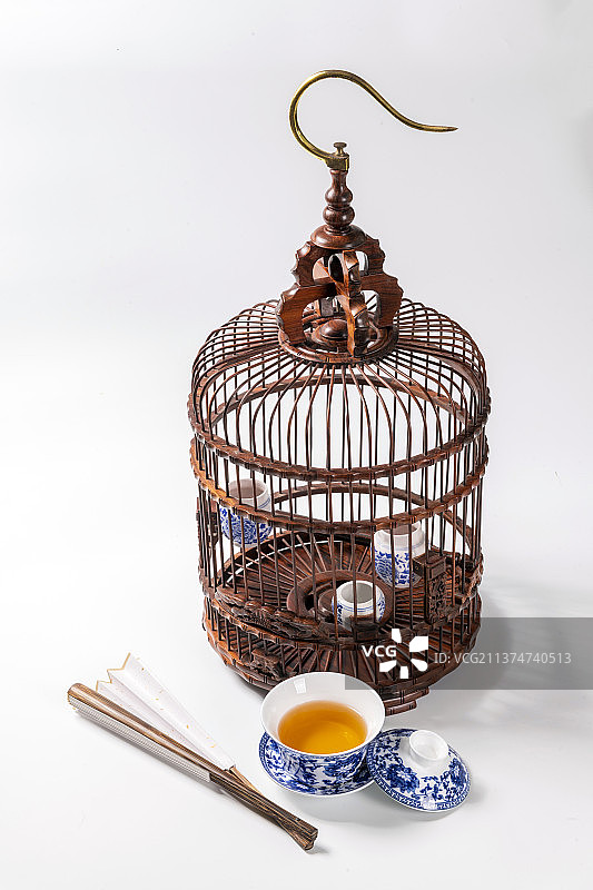红木鸟笼折扇盖碗茶文玩核桃摆放在白色背景上特写图片素材