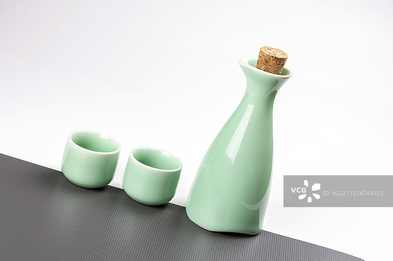 日式酒壶酒杯摆放在灰白相间的背景上特写图片素材