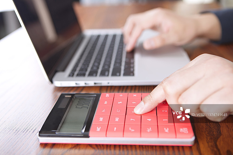 使用计算器和电脑工作的人图片素材