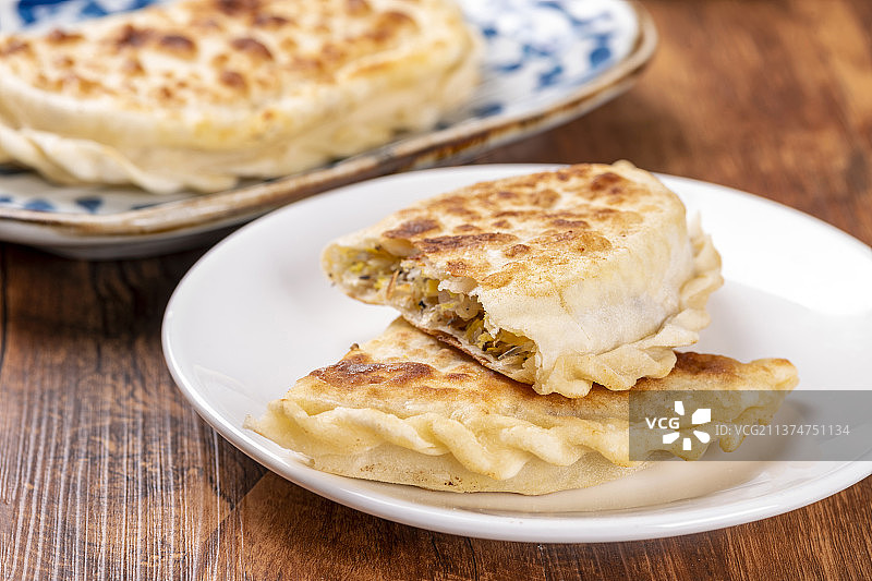 一盘素合子摆放在木桌面上特写图片素材