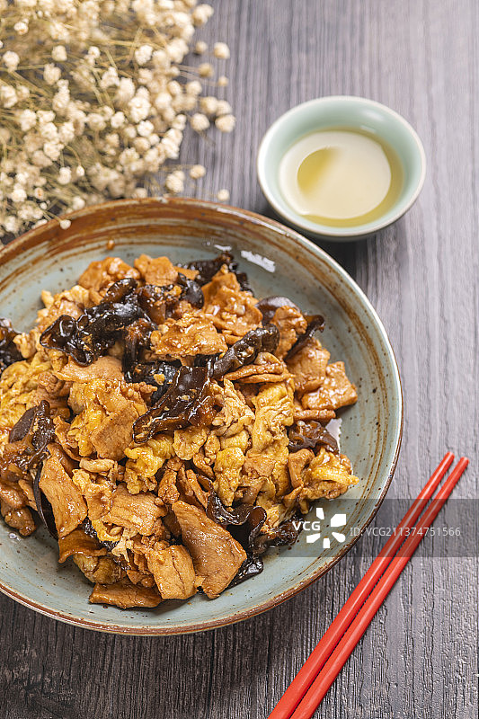 一盘醋溜木须与茶水特写木桌面背景图片素材