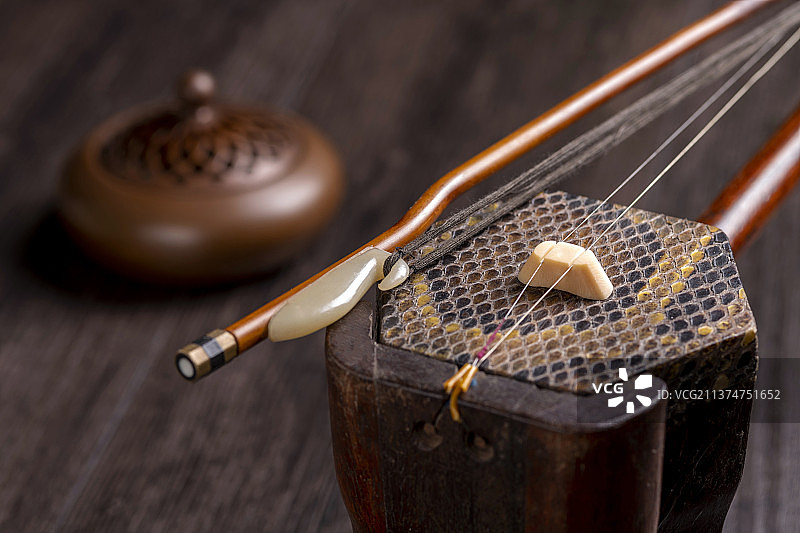 一把传统乐器二胡摆放在古窗影木桌面上特写图片素材