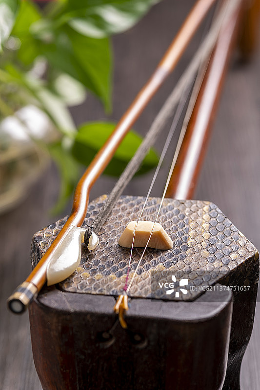 一把传统乐器二胡摆放在古窗影木桌面上特写图片素材