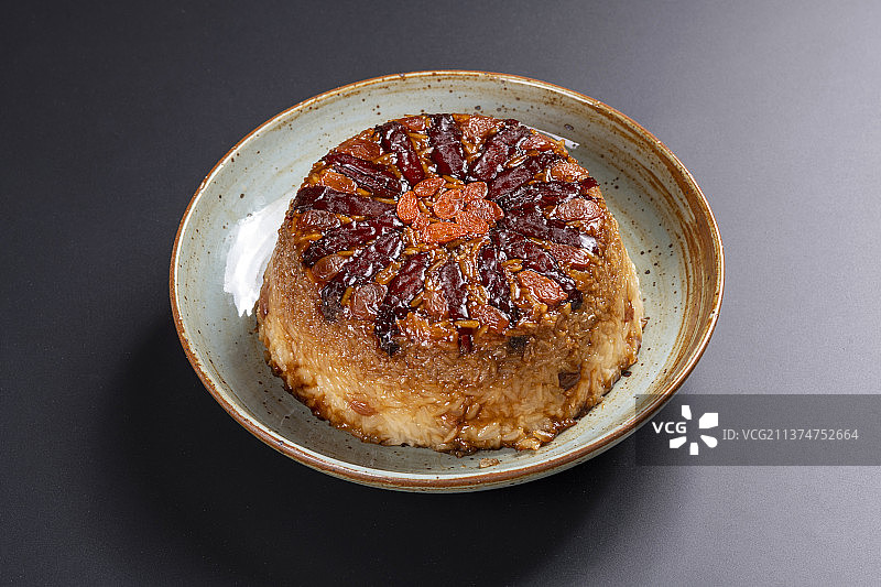 一盘营养滋补的八宝饭特写黑色背景图片素材