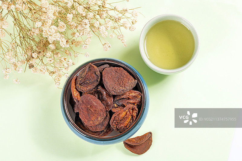 一盘果脯杏干茶水摆放在桌面上特写图片素材