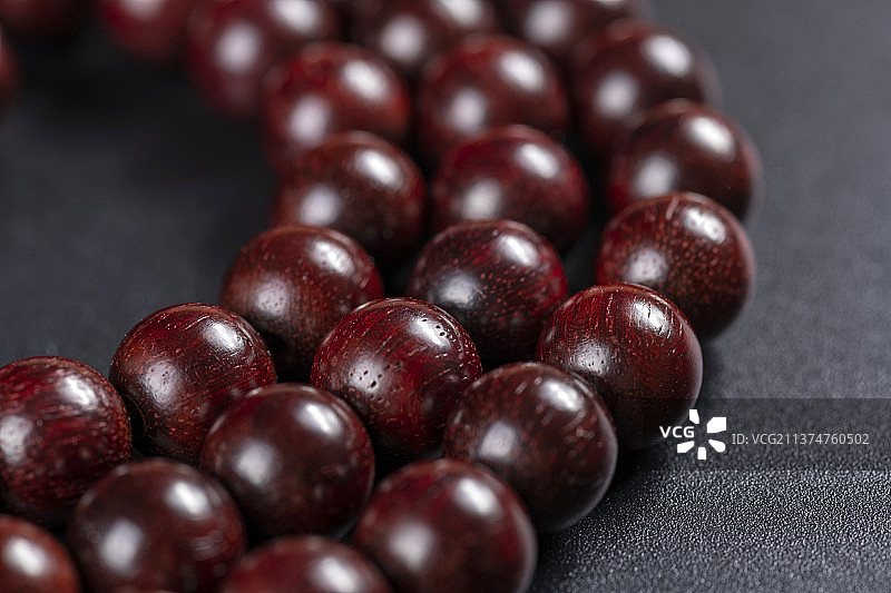 一串小叶紫檀108颗手串摆放在黑色背景上图片素材