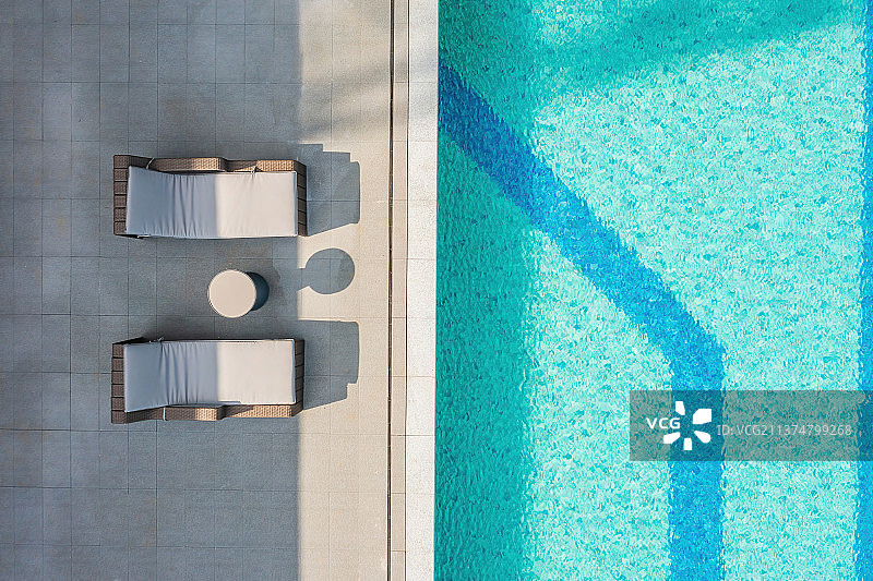 俯拍游泳池和泳池边的休闲躺椅图片素材