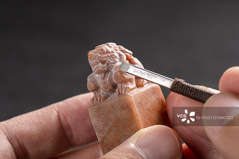 正在雕刻印章狮子钮深色背景图片素材