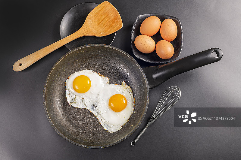 平底锅煎鸡蛋特写黑色背景图片素材
