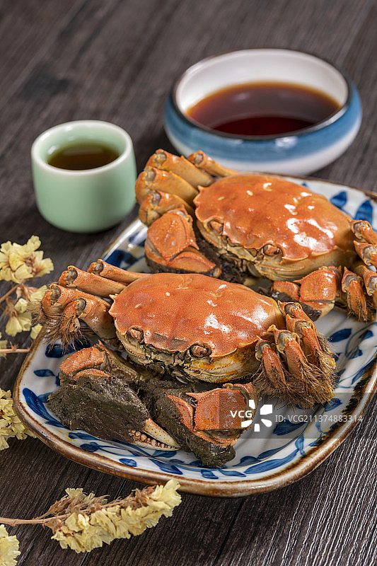 一盘大闸蟹河螃蟹与酒壶酒杯调料碟特写木桌面背景图片素材