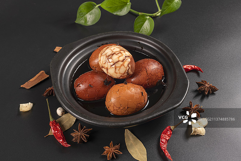 一盘茶叶蛋茶水香料摆放在黑色背景特写图片素材