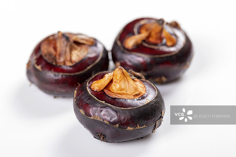 一盘荸荠与茶壶茶杯摆放在桌面上特写图片素材