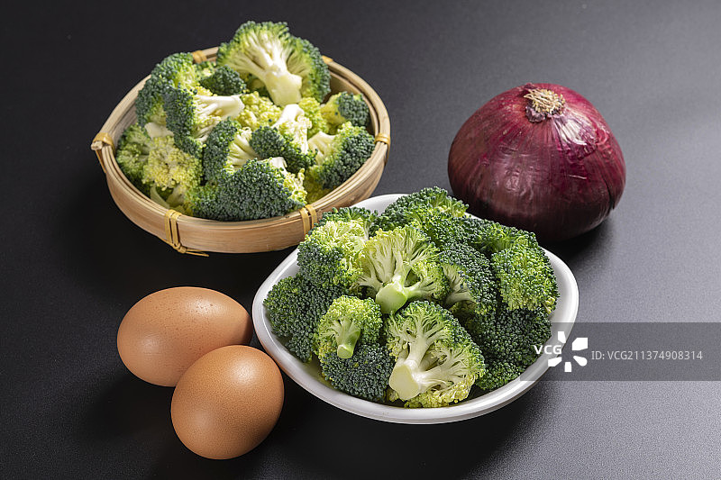 一盘西蓝花与鸡蛋洋葱摆放在桌面上特写图片素材