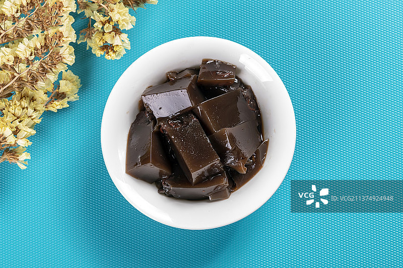 一碗龟苓膏与勺子摆放在桌面上图片素材