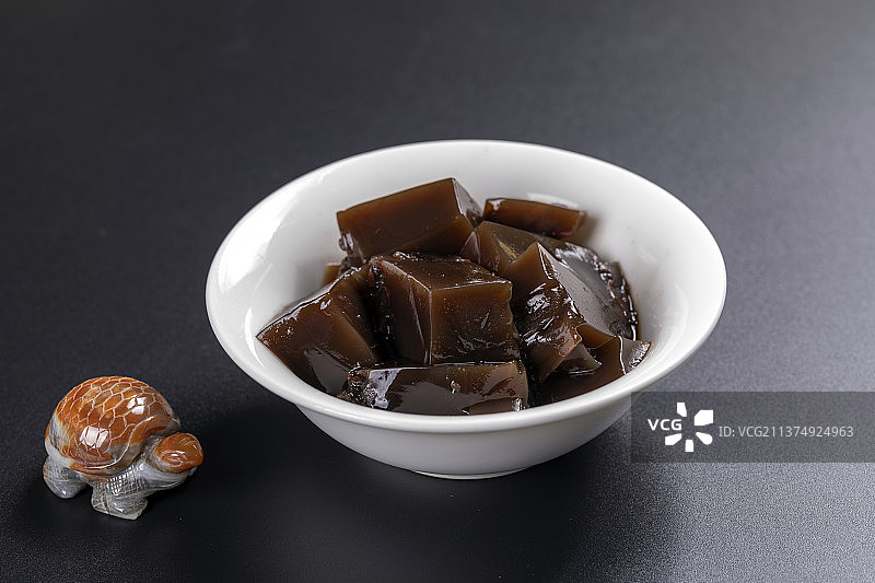 一碗龟苓膏与勺子摆放在桌面上图片素材